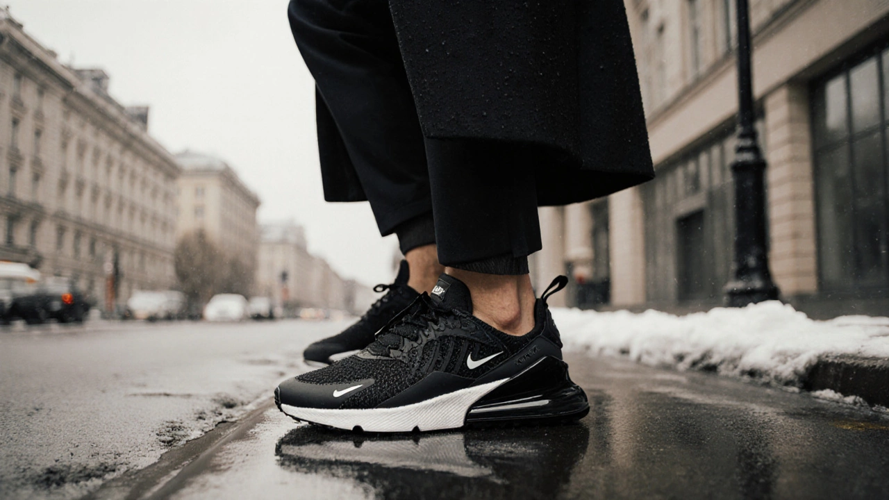 Мужчина в деловом образе шагает по мокрому асфальту в черных кроссовках Nike Air Max 270 React ENG.